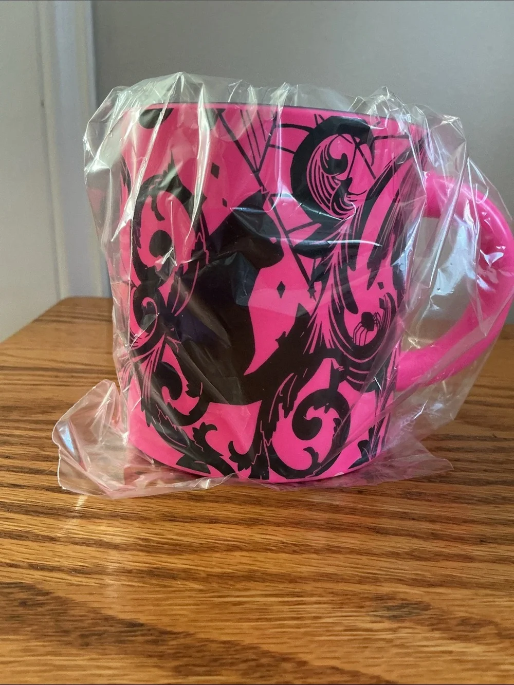 Starbucks Halloween 2021 neon pink coffee mug features a bold black cat-spider.